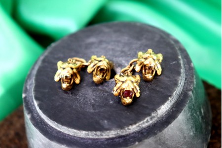 Botões de punho em ouro com relevos e figuras de leões profusamente definidas.